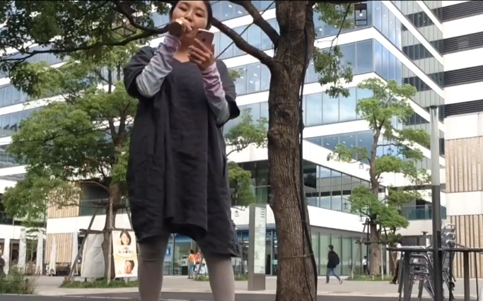 中野駅近くの公園で歌を歌う女性